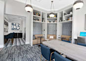 Thumbnail 23 of 53 - A modern office space with a long table, chairs, and a laptop on a desk.