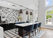 Thumbnail 28 of 53 - A modern kitchen with a black and white checkered floor.