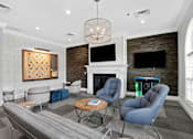 Thumbnail 26 of 53 - A living room with a grey couch, a coffee table, and a fireplace.