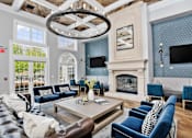 Thumbnail 17 of 53 - A living room with a fireplace and a large chandelier.