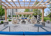 Thumbnail 41 of 53 - A wooden pergola with a table and chairs underneath it.