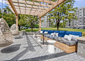 Thumbnail 42 of 53 - A patio with a blue couch and a white toilet.