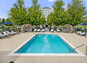Thumbnail 33 of 53 - A large swimming pool surrounded by trees and lounge chairs.