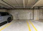 Thumbnail 15 of 47 - A car is parked in a parking garage with yellow lines on the floor.