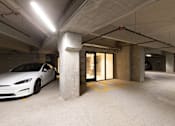 Thumbnail 19 of 47 - A Tesla car is parked in a parking garage.