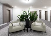 Thumbnail 44 of 47 - A living room with two chairs, a table, and a plant.