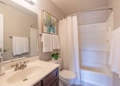 Thumbnail 23 of 23 - A white bathroom with a toilet, sink, and shower.