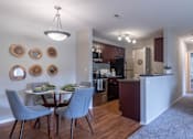 Thumbnail 21 of 23 - A kitchen with a dining table and chairs.