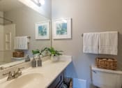 Thumbnail 22 of 23 - A bathroom with a white sink and a white toilet.