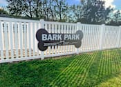 Thumbnail 19 of 44 - A sign that says Bark Park rules stands in front of a white fence.
