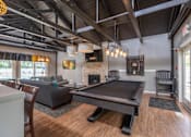 Thumbnail 35 of 44 - A pool table is in the middle of a room with a fireplace and a couch.