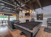 Thumbnail 33 of 44 - A pool table is in the middle of a room with a fireplace and a couch.