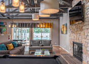 Thumbnail 29 of 44 - A living room with a fireplace and a pool table.