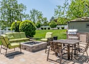 Thumbnail 20 of 44 - A patio with a table, chairs, and a fire pit.