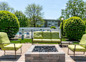 Thumbnail 22 of 44 - A patio with a fire pit and chairs.
