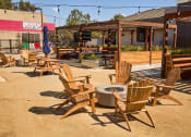 Thumbnail 30 of 30 - a patio with wooden chairs and a fire pit at AVE Santa Clara, Santa Clara