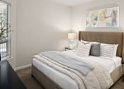 Thumbnail 3 of 18 - A bed with a white comforter and pillows is in the center of the image.