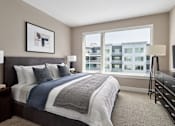 Thumbnail 5 of 15 - A bedroom with a large bed and a view of a building outside the window.