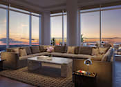 Thumbnail 10 of 14 - A living room with a large couch and a coffee table in front of a window.