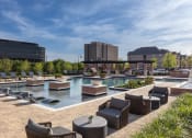 Thumbnail 13 of 13 - a resort style pool with lounge chairs and tables at AVE Las Colinas, Irving, Texas