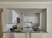 Thumbnail 8 of 18 - A modern kitchen with a bowl of fruit on the counter.