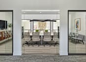 Thumbnail 9 of 18 - A conference room with glass walls and a carpeted floor.