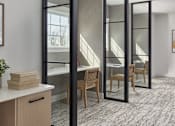 Thumbnail 16 of 18 - A room with a desk, chair, and a large mirror.