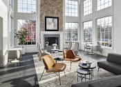 Thumbnail 14 of 18 - A living room with a stone fireplace and a large window.