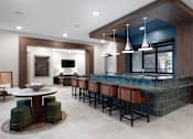 Thumbnail 13 of 19 - A modern bar area with a round table and bar stools at AVE Paradise Valley, Phoenix, 85032