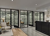 Thumbnail 17 of 30 - A room with a glass door and a wooden floor.