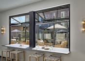 Thumbnail 24 of 30 - A modern bar with a view of the outdoors through large windows.