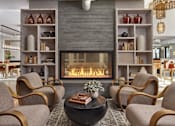 Thumbnail 22 of 30 - A living room with a fireplace and chairs.