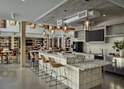 Thumbnail 23 of 30 - A modern kitchen with a long bar and stools.