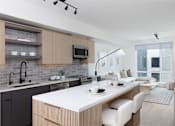 Thumbnail 2 of 30 - a kitchen with a large island and a living room with a couch at AVE Santa Clara, Santa Clara, CA