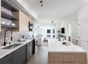 Thumbnail 1 of 30 - a kitchen and living room with a white counter top and a sink at AVE Santa Clara, California