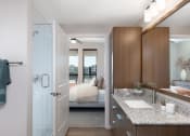 Thumbnail 19 of 20 - a bathroom with a sink and a mirror and a bedroom in the background at AVE Phoenix Terra, Phoenix, AZ, 85003