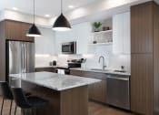 Thumbnail 12 of 20 - a kitchen with a island and a stainless steel refrigerator at AVE Phoenix Terra, Arizona, 85003