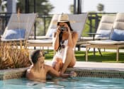 Thumbnail 16 of 20 - a woman in a pool taking a picture of a man in the water at AVE Phoenix Terra, Phoenix, AZ