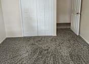 Thumbnail 9 of 18 - A room with a white door and carpeted floor.