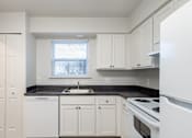 Thumbnail 27 of 28 - A kitchen with white cabinets and appliances.