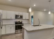 Thumbnail 3 of 18 - a kitchen with white cabinets and a granite counter top at The Augustan, Augusta, 30901