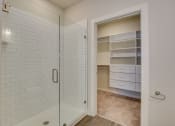 Thumbnail 10 of 18 - a white tiled bathroom with a shower and a closet at The Augustan, Augusta, Georgia