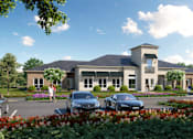 Thumbnail 2 of 18 - A modern house with a grey roof and a large front yard with a flower bed and parked cars.