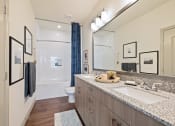 Thumbnail 26 of 39 - Apartment bathroom with double vanity sinks and custom framed mirror