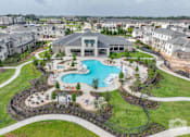 Thumbnail 1 of 18 - A large building with a pool in front of it.