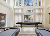 Thumbnail 20 of 32 - a game room with a pool table and ping pong table in front of a large window
