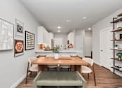 Thumbnail 11 of 18 - A dining room with a table and chairs.