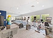 Thumbnail 25 of 32 - a spacious fitness center with cardio machines and weights