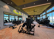 Thumbnail 7 of 18 - A gym with a variety of equipment including treadmills, weights, and exercise machines.