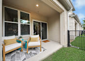 Thumbnail 18 of 18 - A white patio with chairs and a table.